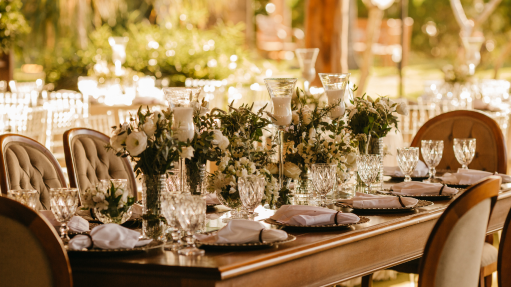 gedeckte Hochzeitstafel mit Blumenvasen und Kerzen