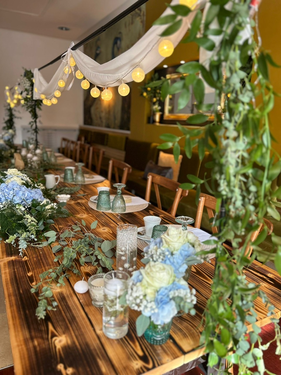 Tischdekoration Brauttisch mit Blumengesteck und Lichterkette